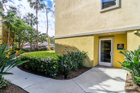 A yellow building with a glass door and a small window above it.